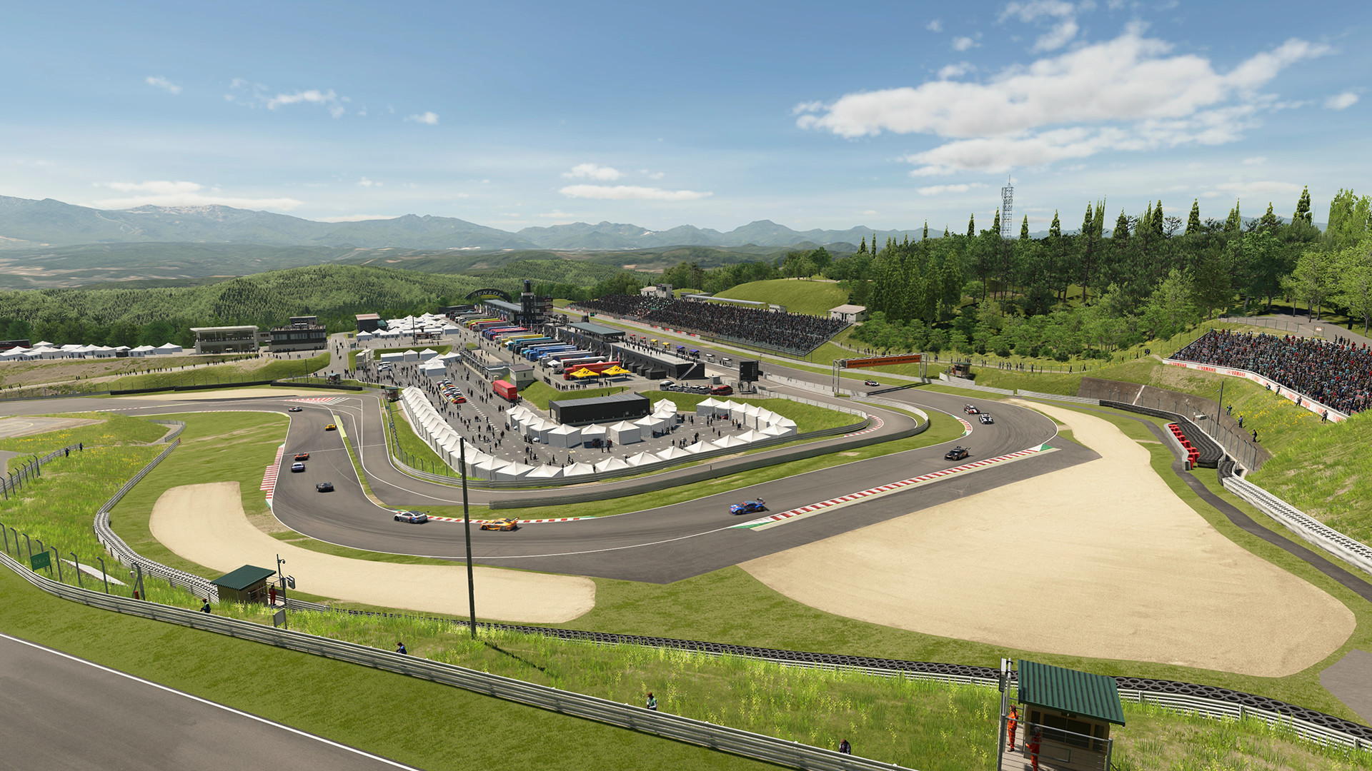 ภาพมุมกว้างสนาม Sportsland SUGO พร้อมอาคารพิทและอัฒจันทร์ใน Gran Turismo 7
